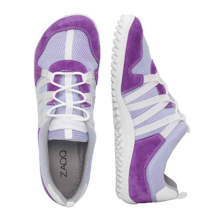 RIQ Purple von ZAQQ – Ein elegantes Paar sportlicher Mesh-Sneaker in Lila und Weiß, die ein minimalistisches Design mit Meshgewebe aufweisen. Sie verfügen über weiße Schnürsenkel, gestreifte Details und strukturierte Sohlen für besseren Halt. Ein Schuh wird aus der Draufsicht gezeigt, während der andere in einer Seitenansicht gezeigt wird.