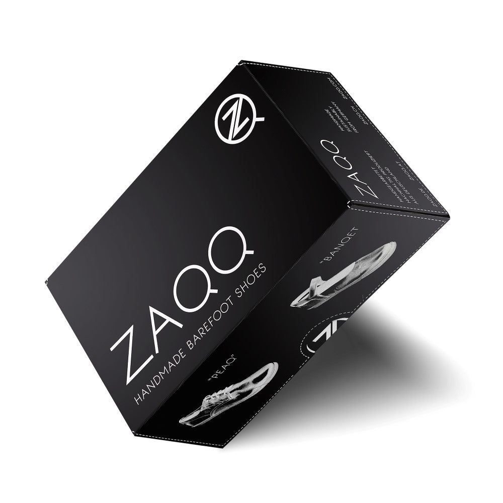 Eine schlichte schwarze Box für die handgefertigten Barfußschuhe STIQ White von ZAQQ, mit dem Markenlogo und einer Skizze eines Barfußschuhs. Das minimalistische Verpackungsdesign umfasst Text und Illustrationen auf allen Seiten und ist somit ideal für Deine neuen Sneaker aus Nappaleder.