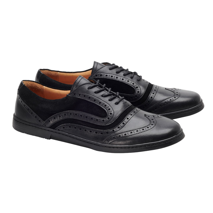 Die Schuhe BRIQ Brogue Deep Black von ZAQQ aus glattem schwarzem Kalbsleder mit dekorativen Perforationen, Schnürsenkeln und niedrigem Absatz werden vor einem schlichten weißen Hintergrund präsentiert.