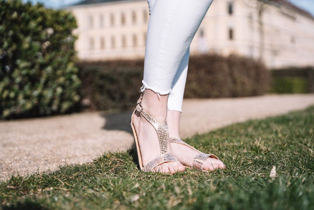 Bei diesen CLIQ Gold-Sandalen von ZAQQ handelt es sich um ein Paar metallisch glänzende Schuhe mit T-Riemendesign und Schnallenverschluss sowie einer flexiblen Sohle für mehr Komfort.