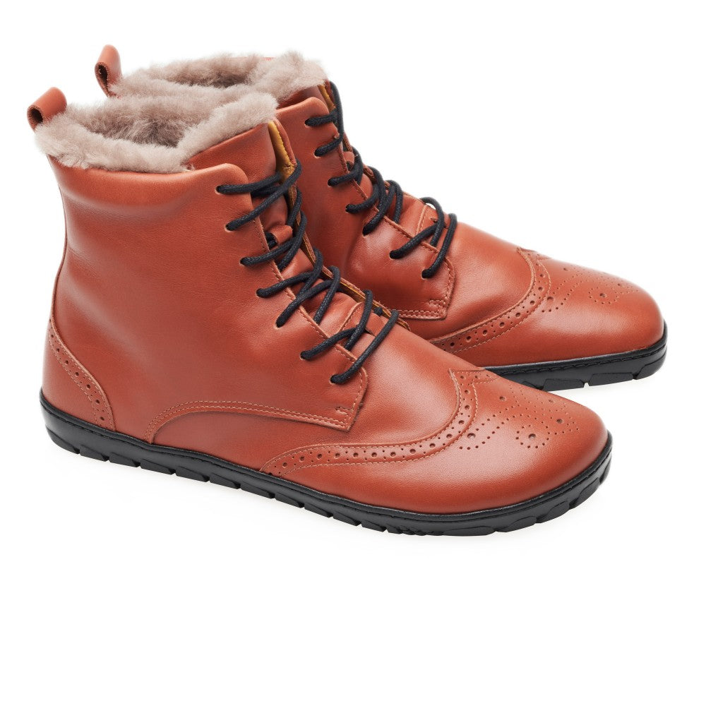 Der QUINTIC Winter Brogue Cognac von ZAQQ aus hochwertigem Nappaleder verfügt über elegante Flügelkappendetails mit schwarzen Schnürsenkeln und Sohlen. Diese Stiefeletten aus braunem Leder sind mit kuscheligem beigem Lammfell gefüttert, das an der Oberkante hervorschaut.