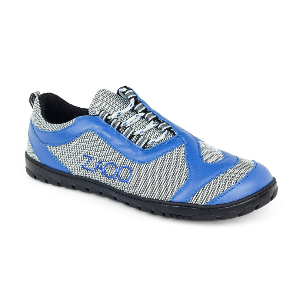 Entdecken Sie den ZAQQ QUIQ Trail Blue, einen sportlichen Barfußschuh in Blau und Grau mit schwarzer Sohle. Sein Mesh-Gewebe bietet Atmungsaktivität, während das ikonische Zaoo-Logo einen stilvollen Touch verleiht. Ergänzt durch blaue und weiße Schnürsenkel ist er die perfekte Balance zwischen Mode und Funktionalität.