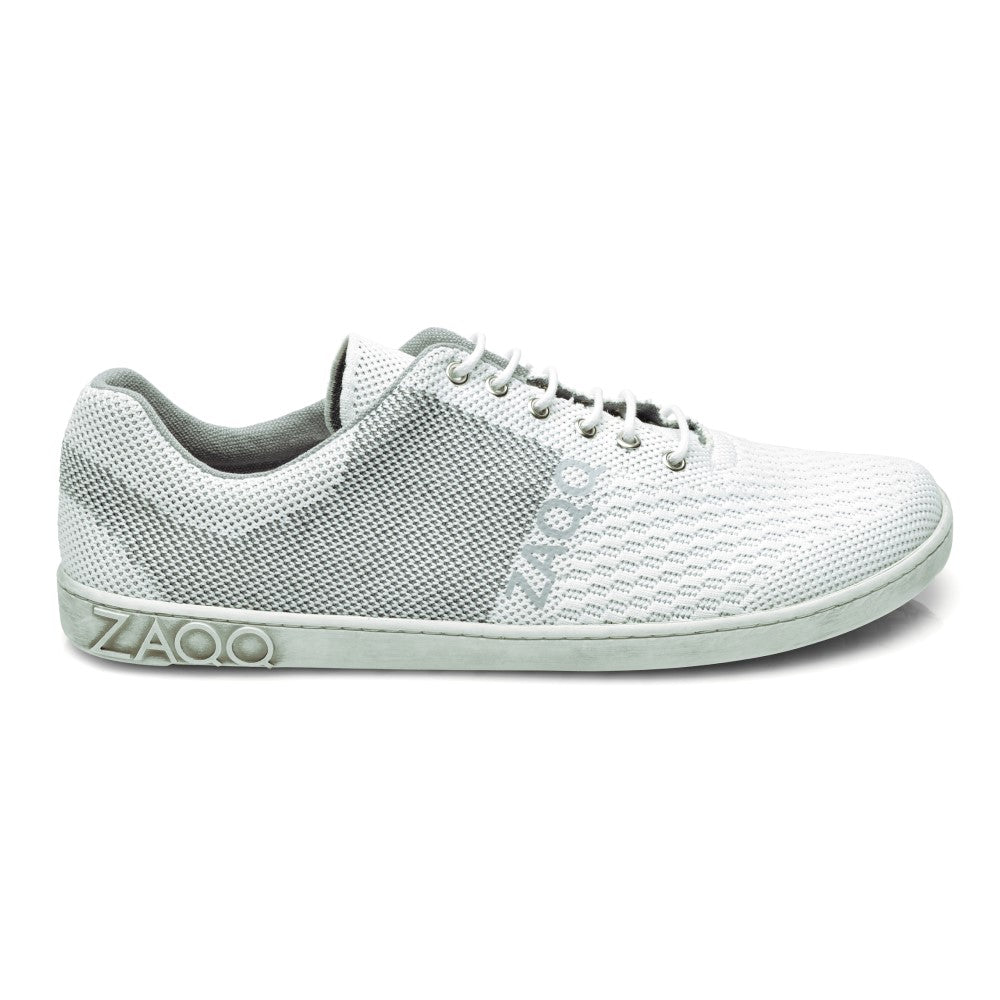 Der QNIT White ist ein minimalistischer Sneaker aus strukturiertem Stoff mit Schnürung, auf dessen rutschfester Sohle der Markenname ZAQQ eingeprägt ist.