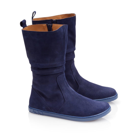 Diese modischen QOM Blue-Stiefel von ZAQQ sind aus marineblauem Ziegenveloursleder gefertigt, haben eine mittlere Wadenhöhe und flache Sohlen. Sie zeichnen sich durch ein dezentes, lässiges Design aus und verfügen über seitliche Reißverschlüsse für einfaches Tragen. Die ZAQQ-Barfußsohle bietet eine glatte Traktion, während das Innere für mehr Komfort mit hellbraunem Material gefüttert ist.